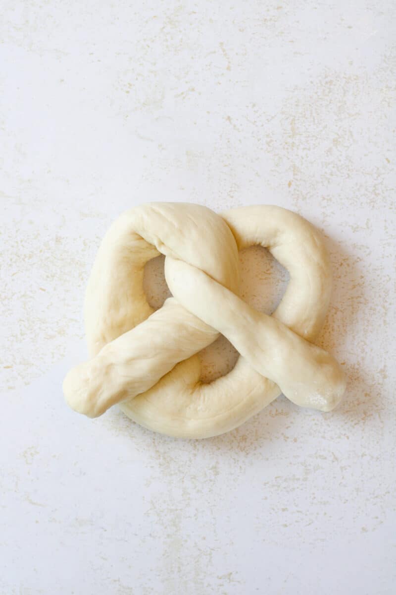 Uncooked shaped pretzel dough on a counter.