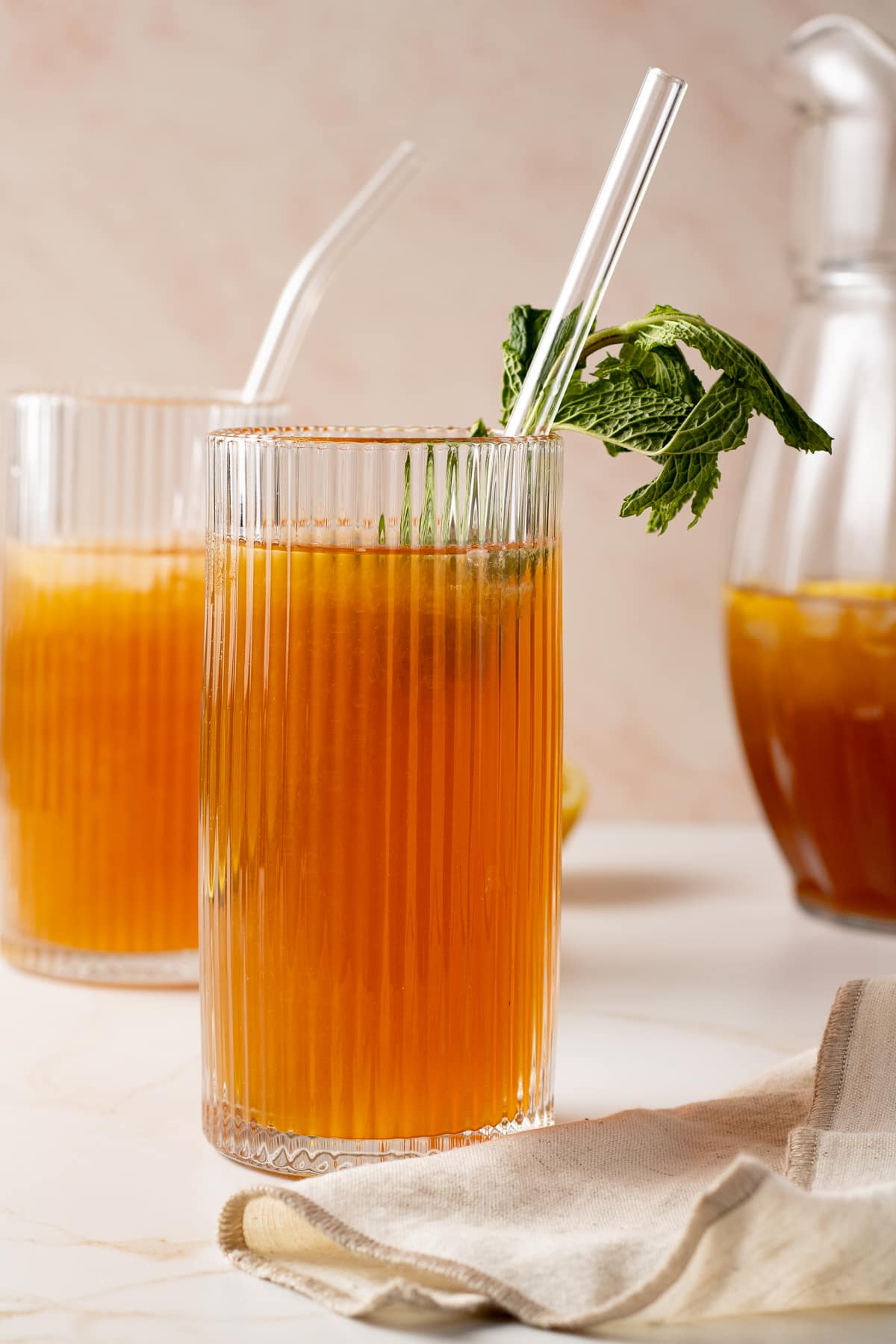 Tea lemonade in a glass with a sprig of fresh mint.