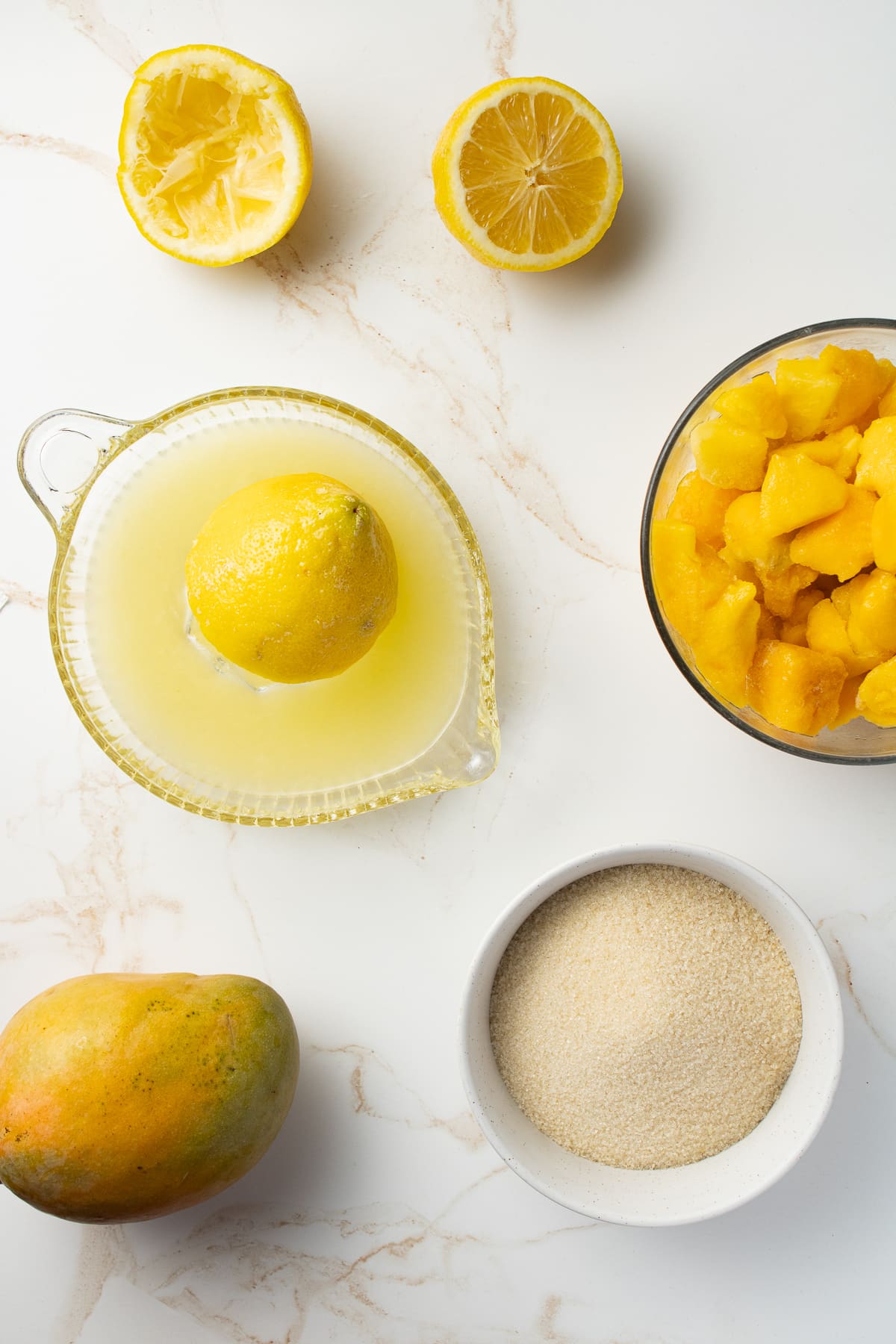 Overhead image of mango lemonade ingredients on a counter.